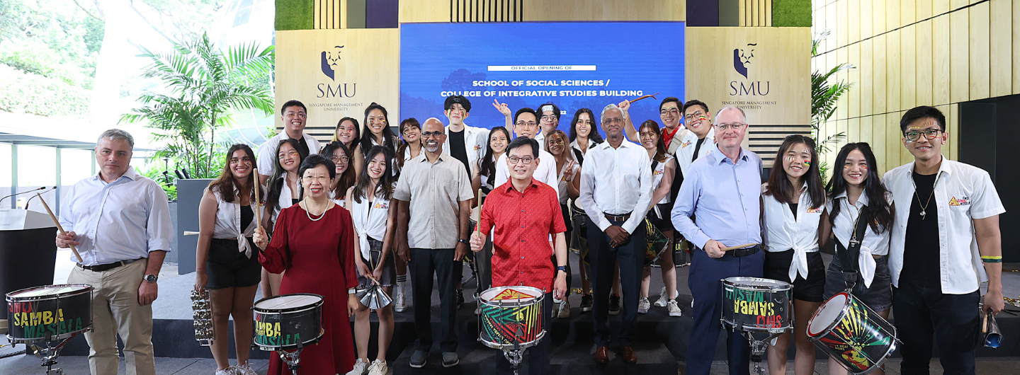 Group poses with drums for SMU School of Social Sciences building opening event.